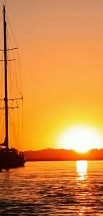 Sailboat on a tranquil orange sunset backdrop with serene water.