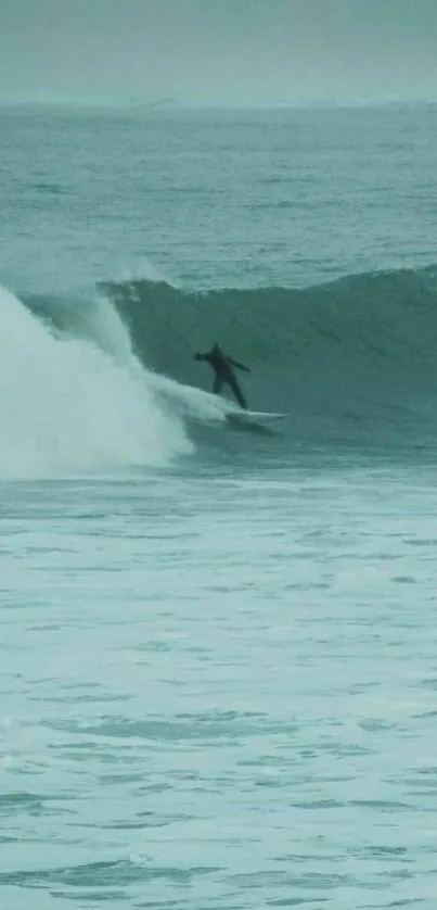 Surfer riding a powerful teal wave.