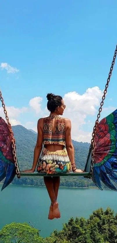 Woman on a winged swing overlooking a scenic lake and blue sky.