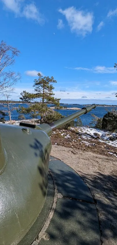 Tank overlooking ocean and trees under blue sky.