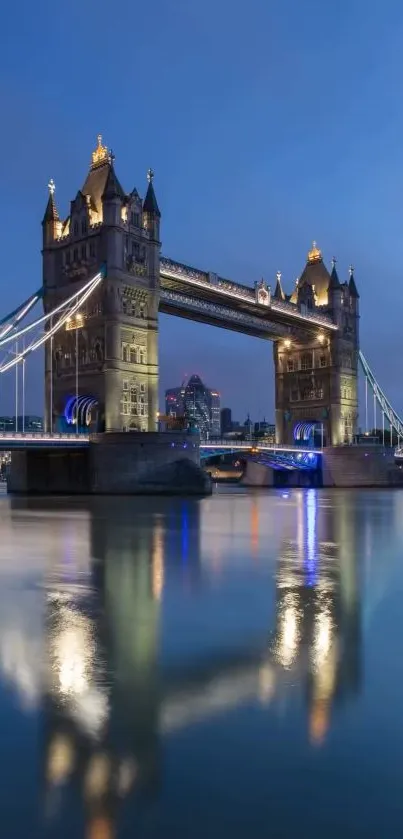 Tower Bridge at night with city lights reflecting on the calm water.