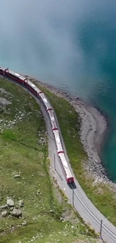 A scenic train winds beside a tranquil blue lake with lush green surroundings.