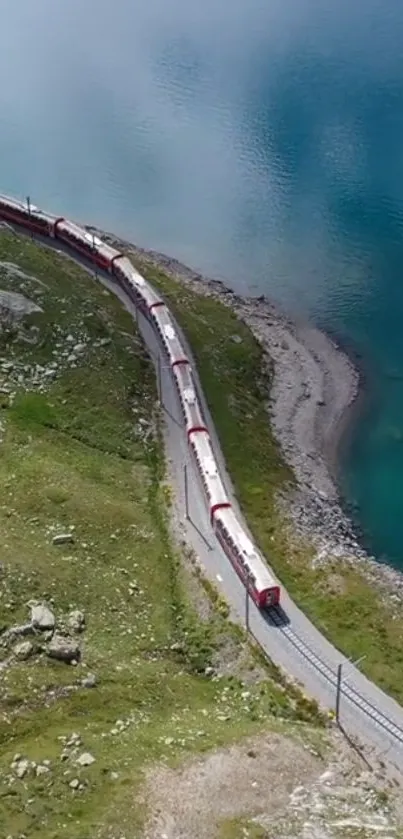 Red train winding along a vibrant teal blue lake and green landscape.