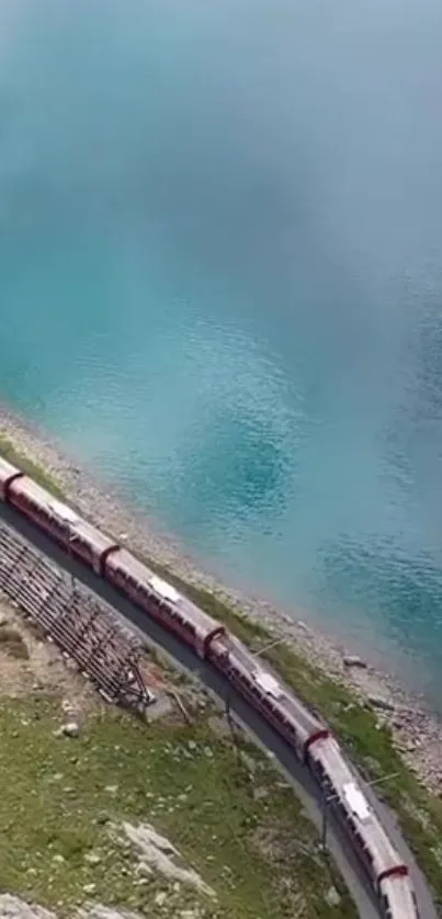 A train traveling alongside a stunning blue lake with a scenic natural backdrop.