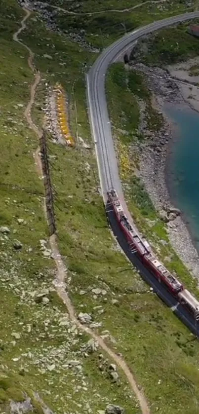 A train curves by a turquoise lake surrounded by lush green mountains.