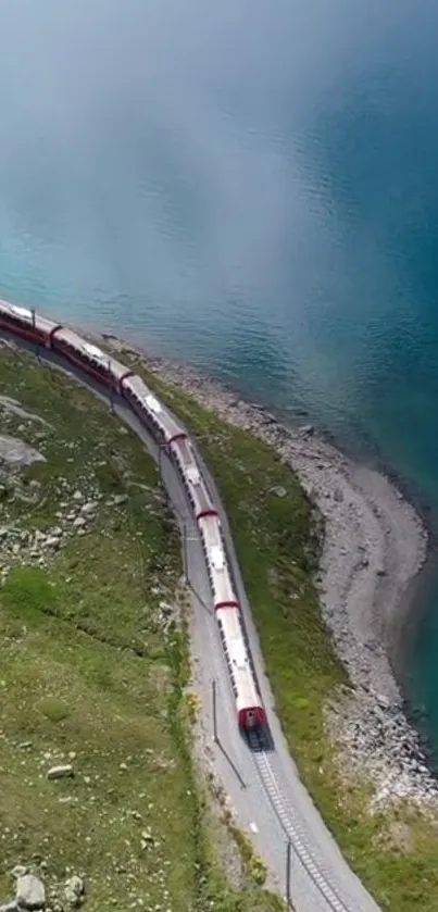 Aerial shot of a train by a turquoise lake.