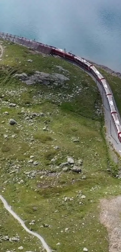 A train winding through lush green hills next to blue waters.