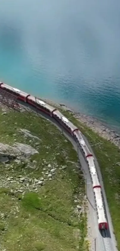 Red train winding by a turquoise lake on a mountainous path.