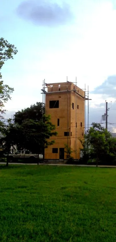 Urban tower with lush greenery and cloudy sky backdrop.