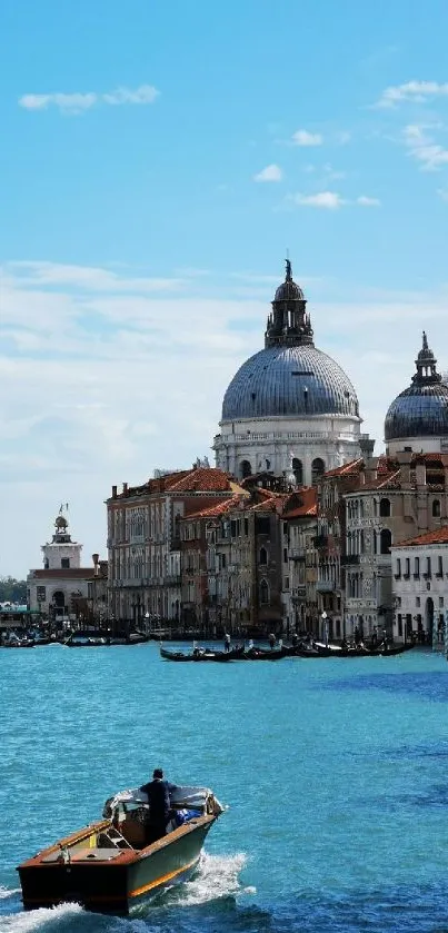 Venice canal with historic buildings and a boat under a blue sky.