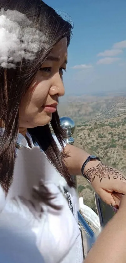 Woman with henna art against a cloudy sky.