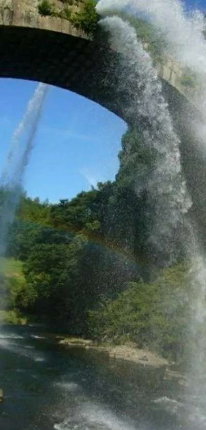 Waterfall over stone bridge with blue sky.