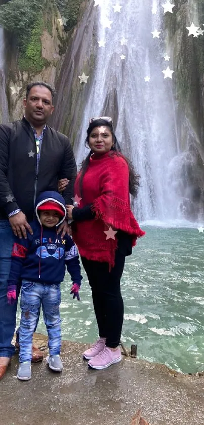 Family posing in front of a large flowing waterfall.