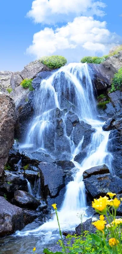 Waterfall cascading over rocks with wildflowers in foreground.