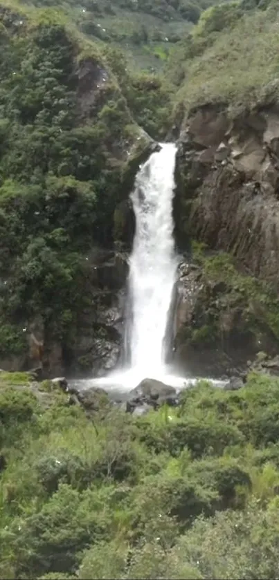 Lush green landscape with waterfall cascading down rocky terrain.