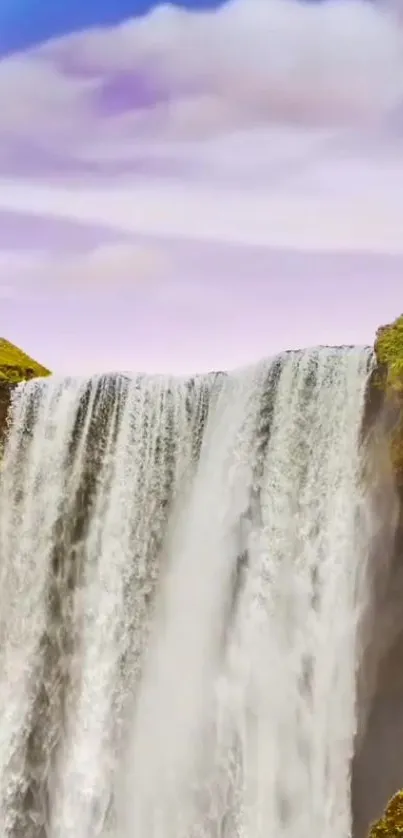 Majestic waterfall with a vibrant rainbow overhead, against a blue sky backdrop.