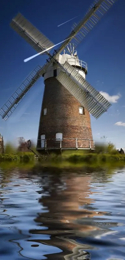 Scenic windmill with water reflection under clear blue sky.