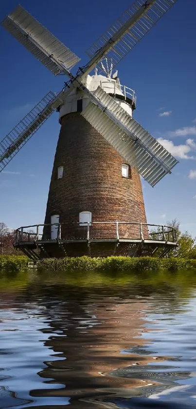 Picturesque windmill by the water under a clear blue sky.