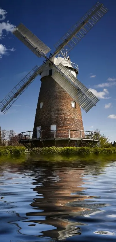 Scenic windmill with water reflection under blue sky wallpaper.