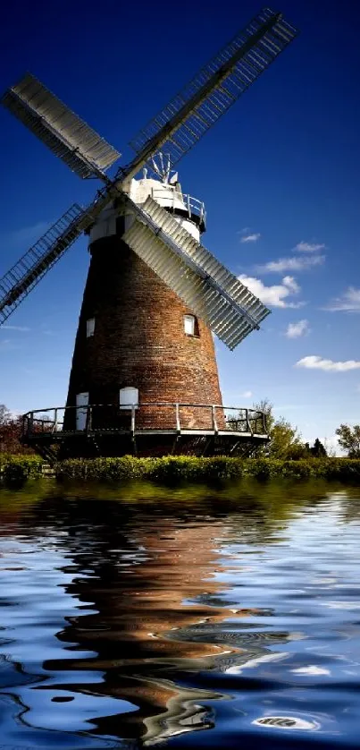 Mobile wallpaper of windmill reflecting on water under a blue sky.