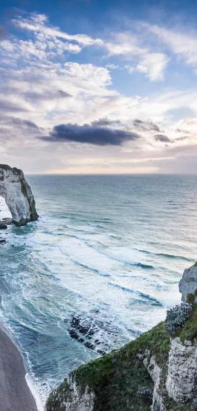 Sunset view of a seaside cliff with waves and a vibrant sky.