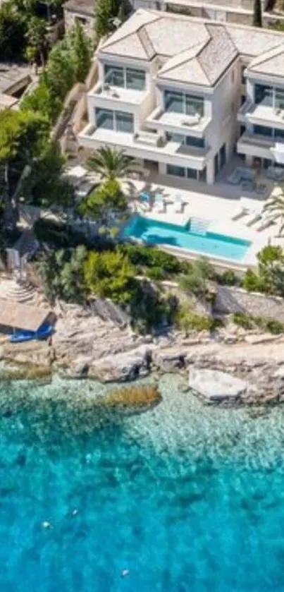 Aerial view of a luxury seaside villa with pool and turquoise ocean.