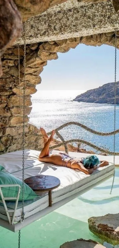 Hanging bed by the ocean in a rocky cave with turquoise water and sunny skies.