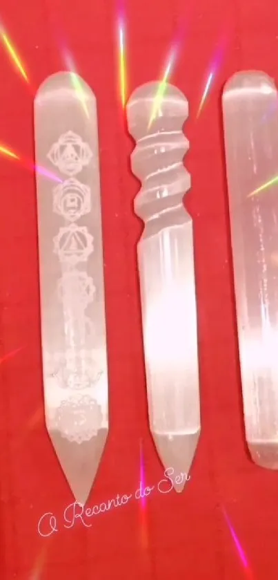 Selenite crystal wands on a vibrant red background with colorful light reflections.