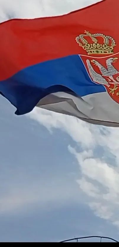 Serbian flag waving against a blue sky.