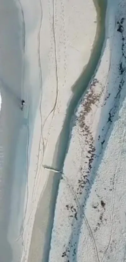 Aerial view of serene beach with blue waves and sandy shore.