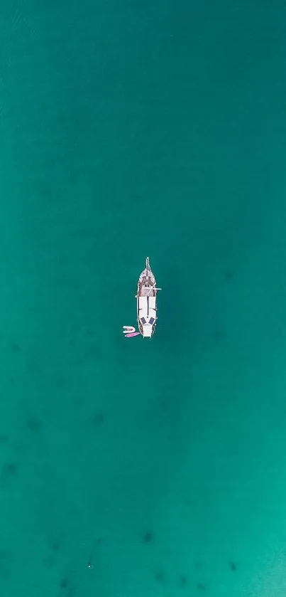 Aerial view of a boat on a teal ocean background.