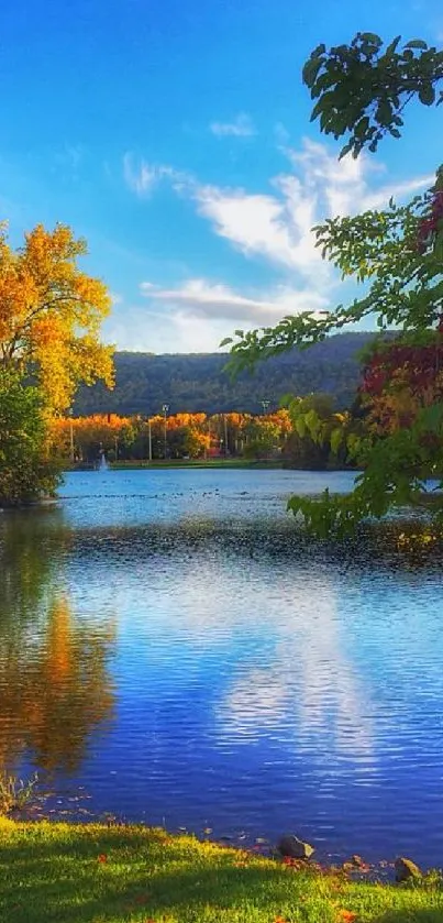 Serene lake with autumn trees and a clear blue sky.