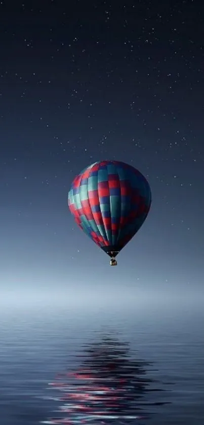 Colorful hot air balloon over calm water at night.