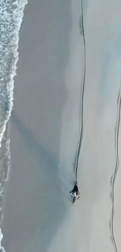 Aerial view of a serene sandy beach with turquoise waves hitting the shore.