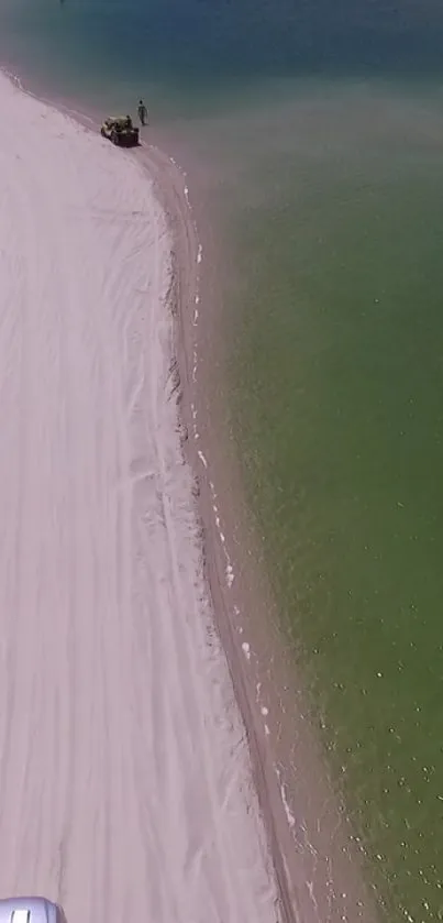 Aerial view of a beach with white sand and greenish-blue waters.