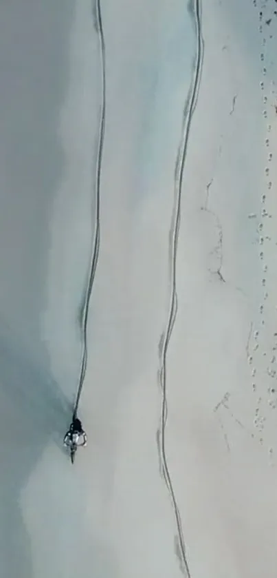 Aerial view of beach with sand and ocean waves.