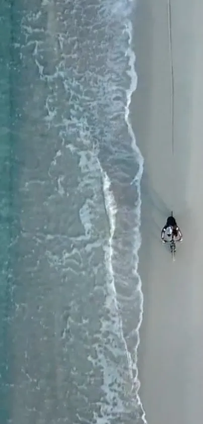 Aerial view of a serene beach with waves and sand.