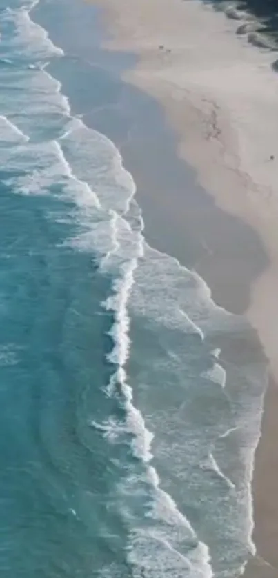 Aerial view of a sandy beach with gentle ocean waves.