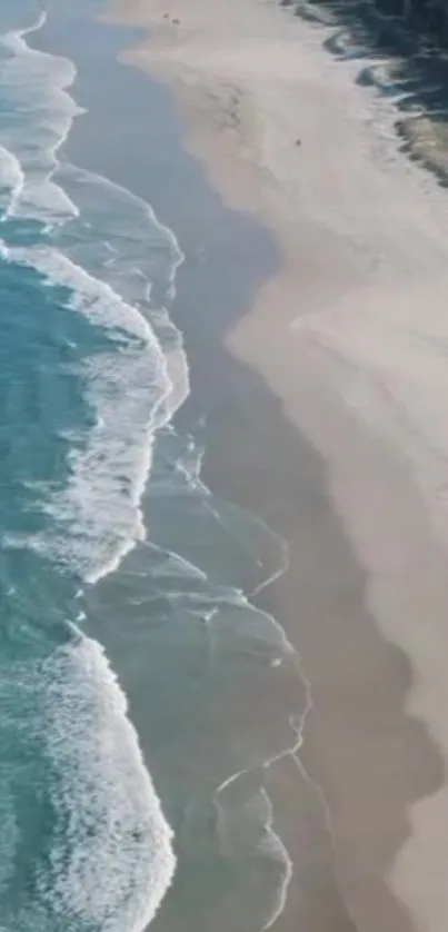 Aerial view of turquoise waves and sandy beach.