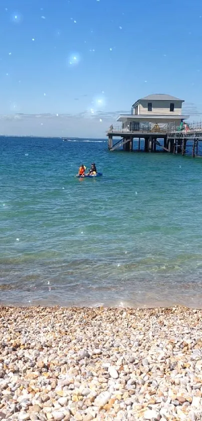 Scenic beach with floating pier under clear blue sky.