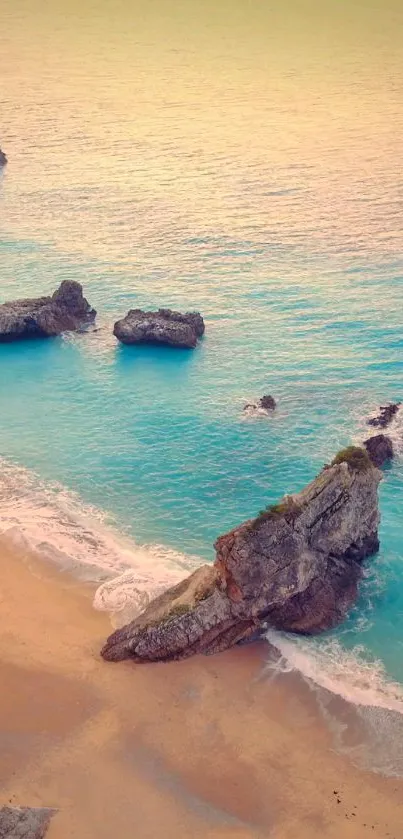 Beach at sunset with rocks and turquoise waters, perfect for mobile wallpaper.