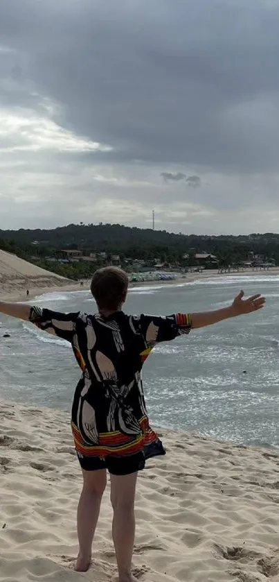 A person opens arms on a serene beach with palm trees and ocean.