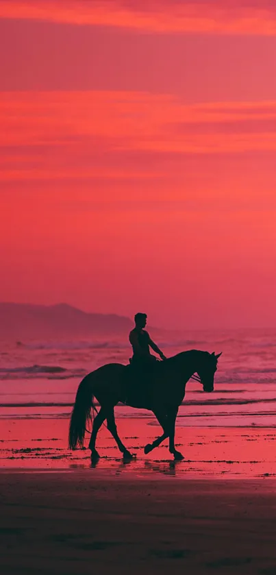 Horse and rider on beach at sunset, with pink sky.