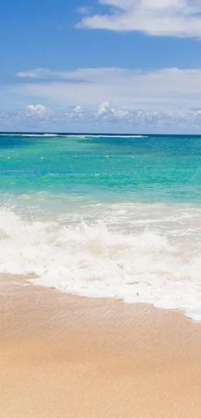 Calm beach with turquoise ocean and golden sand under a sunny sky.