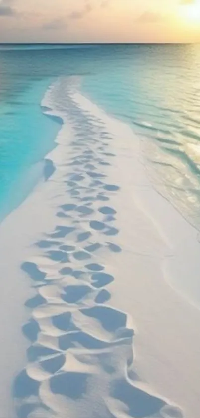 Footprints leading down a serene beach at sunset with ocean waves.