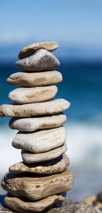 Stacked pebbles on a beach with ocean waves in the background.