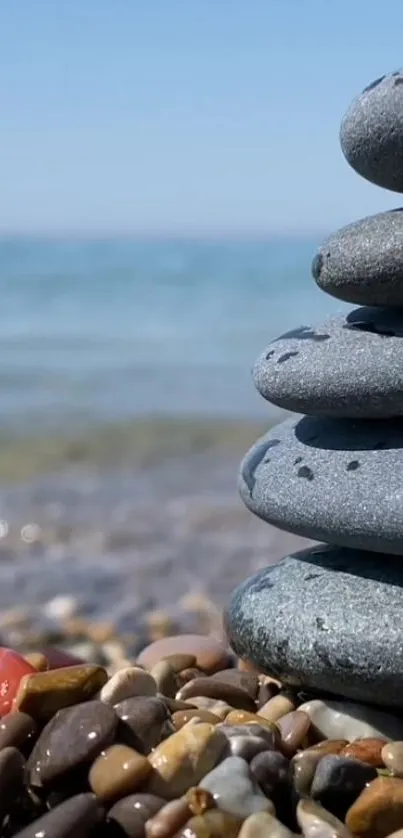 Stack of smooth pebbles on a tranquil beach shore.