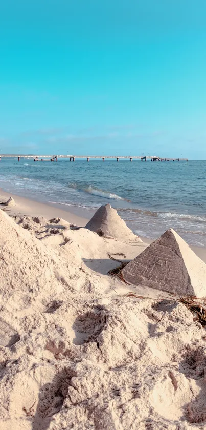 Beach with sand pyramids and a clear blue sky.