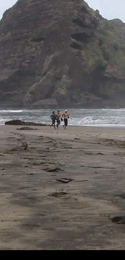 Beach with a large rock formation at the ocean's edge.