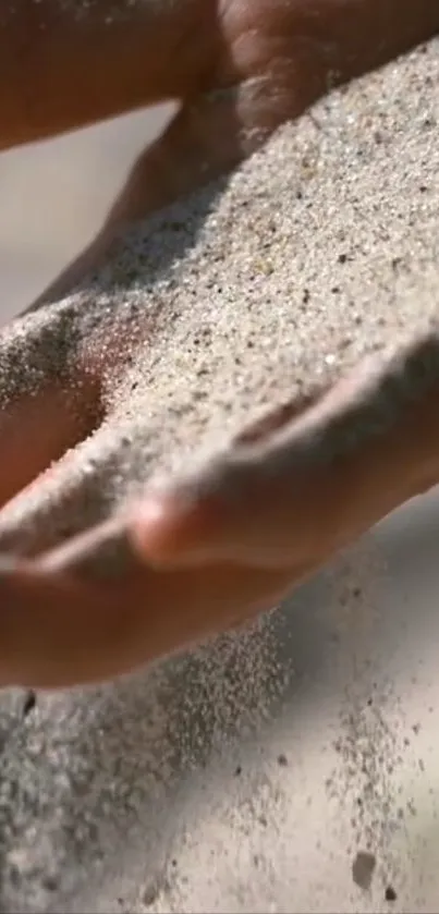 A close-up of sand flowing through fingers on a beach.